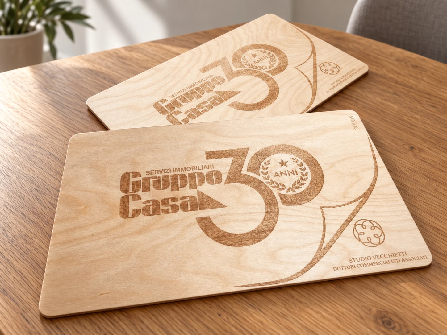 Due tavolette in legno con incisione Gruppo Casa 30 anni e marchio Studio Vecchietti · mockup ambientato