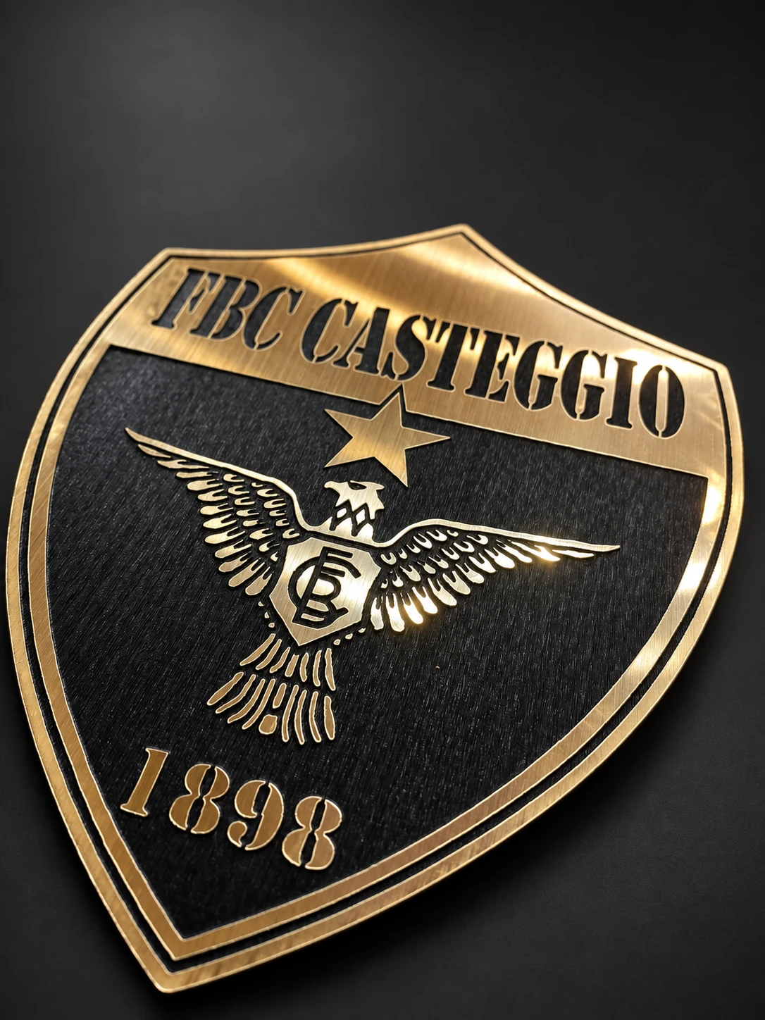 Targa a scudo FBC Casteggio 1898 con aquila e stella dorate su fondo scuro